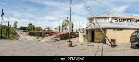 RICHMOND, SÜDAFRIKA - 2. APRIL 2021: Eine Panorama-Straßenszene in Richmond im nördlichen Kap Karoo. Ein Supermarkt, Menschen und Damm und pedest Stockfoto