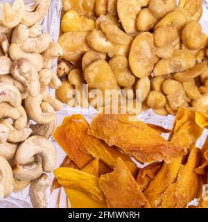 Geröstete und gesalzene Fava-Bohnen, Cashewnüsse und getrocknete Mangoscheiben für einen gesunden veganen und vegetarischen Ernährungs-Snack. Hoch in Protein, Vitamine, Diät-Fi Stockfoto