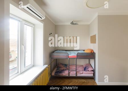 Fragment der modernen Inneneinrichtung mit Etagenbett in Nische in der Nähe Fenster in modernen kleinen Wohnung mit minimalistischem Stil Design platziert. Kinderzimmer Stockfoto