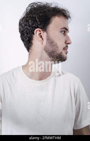 Das Seitenprofil eines bärtigen kaukasischen Mannes in Weiß shirt auf weißem Hintergrund Stockfoto