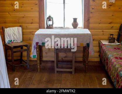 Zimmereinrichtung eines alten Landhauses in Russland, Strickmuster auf Tischdecken. Holzhütte Stockfoto