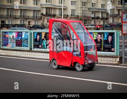 Ein Mann fährt sein Mobilitätsfahrzeug entlang der Promenade an Brighton Stockfoto