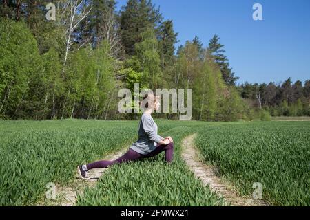 Junge süße Teenager-Mädchen tun Stretching-Übungen in der Natur. Ein aktiver Lebensstil, Ruhe mit Nutzen Stockfoto