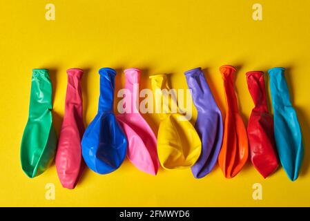 Bunte Luftballons liegen wunderschön auf einem gelben Hintergrund Stockfoto