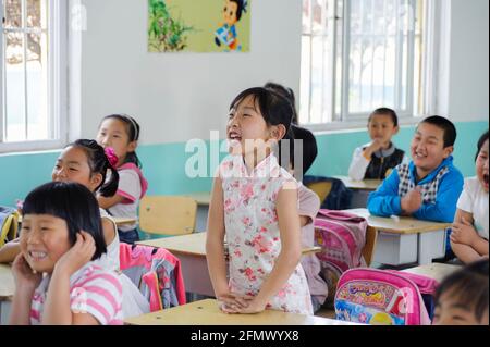 Schüler heben ihre Hände, um die Frage des Lehrers zu beantworten. Stockfoto