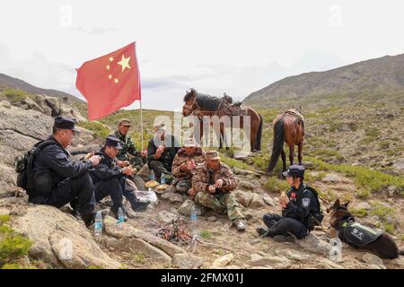 Altay, China. Mai 2021. Die Polizisten patrouillieren am 11. Mai 2021 in Altay, Xinjiang, China, mit Hunden und Pferden an den nationalen Grenzen.(Foto: TPG/cnsphotos) Quelle: TopPhoto/Alamy Live News Stockfoto