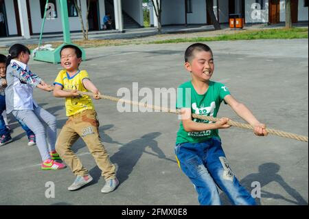 Schüler der Weiqiao Central Primary School in Xiuning, Anhui, China, nehmen an einem Tauziehen-Wettbewerb Teil. Stockfoto