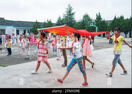 Schüler der zentralen Grundschule Weiqiao in Xiuning, Anhui, China, während der morgendlichen Flaggenanhebung. Stockfoto