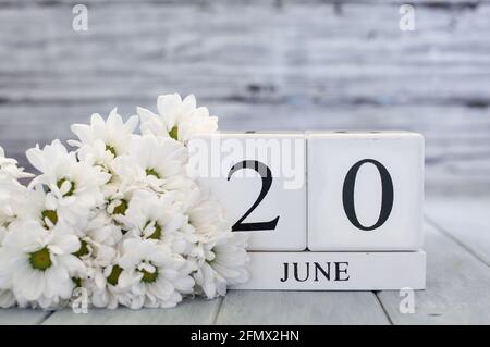 Vatertag, Kalendarblöcke aus weißem Holz mit dem Datum des 20. Juni und weißen Gänseblümchen. Selektiver Fokus mit unscharfem Hintergrund. Stockfoto