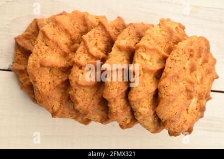 Mehrere runde leckere Cerealien-Kekse, Makro, liegen auf einem Holztisch, Draufsicht. Stockfoto