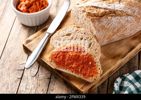 Toastbrot in Scheiben mit Sobrasada auf rustikalem Holztisch Stockfoto