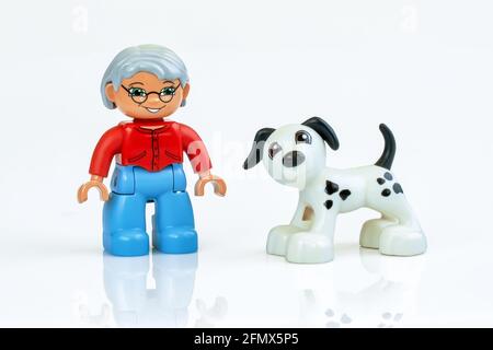 KHARKIV, UKRAINE - 29. März 2020: Spielzeugmann läuft Spielzeug Hund, Plastikspielzeug, Vorschulbildung Thema, isoliert auf weiß Stockfoto