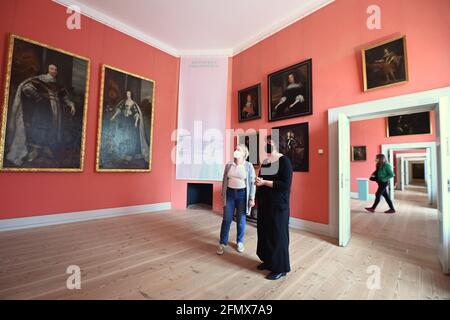 Oranienburg, Deutschland. Mai 2021. Zwei Frauen sprechen im Museum des Schlosses Oranienburg in der Ausstellung „Machtmensch. Familienmitglied Der große Kurfürst" vor den Porträts "König Karl I. von England und Königin Henrietta Maria" von 1637 von Anthonis van Dyck. Die Stiftung Preußische Schlösser und Gärten Berlin-Brandenburg (SPSG) eröffnet den Besuchern die Schlösser Caputh, Rheinsberg und Oranienburg wieder. Quelle: Soeren Stache/dpa-Zentralbild/dpa/Alamy Live News Stockfoto