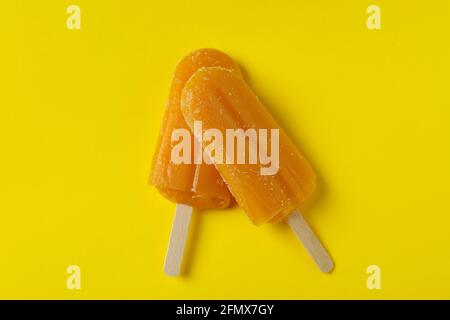 Mango-Eis-Sticks auf gelbem Hintergrund Stockfoto