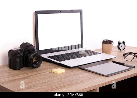 Termin für Fotografen Konzept. Draufsicht auf den Designer-Tisch mit pc-Laptop-Computer, Zeichentisch, Fotokamera, gelbe Memoaufkleber, Wecker, becher Stockfoto