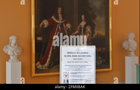 Oranienburg, Deutschland. Mai 2021. Ein Schild begrüßt die Besucher der Ausstellung „Machtmensch. Familienmitglied Der große Kurfürst" vor dem Gemälde "Doppelporträt von Kurfürst Friedrich Wilhelm von Brandenburg und Kurfürst Louise Henriette" von Pieter Nason. Sie weist auch auf die Verpflichtung hin, eine Maske zu tragen und Abstand zu anderen Personen zu halten. Die Stiftung Preußische Schlösser und Gärten Berlin-Brandenburg (SPSG) eröffnet den Besuchern die Schlösser Caputh, Rheinsberg und Oranienburg wieder. Quelle: Soeren Stache/dpa-Zentralbild/dpa/Alamy Live News Stockfoto