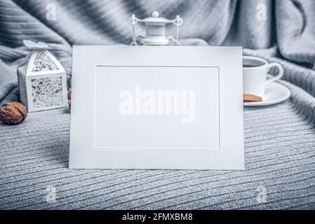 Weißer Rahmen, ein schönes Karli, eine Tasse mit Kaffee und Keksen auf einem Tisch mit Kerzen. Stockfoto