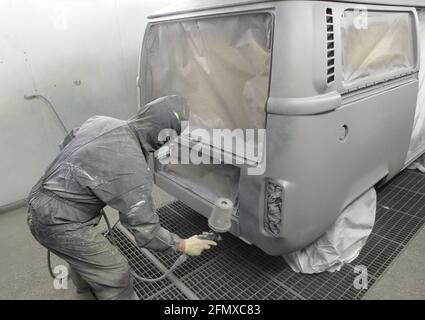 Ein VW-Bus Wohnmobil T2 Baujahr 1977 ist in einer Lackiererei fertig für die letzten Arbeiten. The shared Auto steht fertig geschweisst, gespach Stockfoto