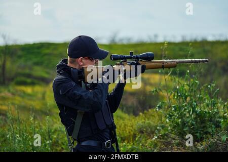 Nahaufnahme eines Polizeigefängers, der auf seinen Bereich zielt Gewehr Stockfoto