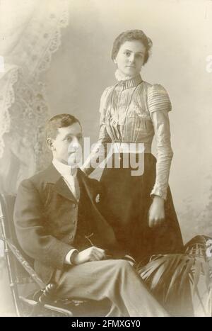 Ursprüngliche verblasste frühe edwardianische Kabinettkarte eines jungen Ehepaars aus den William Harrisons Studios, Falmouth, Cornwall, Großbritannien, datiert um 1902 Stockfoto
