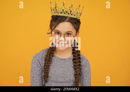 Verleihen Sie Ihrer Schönheit ein Accessoire. Kleine Schönheit Königin gelben Hintergrund. Schönheit Blick des kleinen Mädchens. Junior Abschlussball Party. Schönheit und Mode. Markieren Sie Ihre Stockfoto