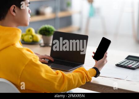 Asiatischer Mann Mit Smartphone Mit Schwarzem Leeren Bildschirm Stockfoto