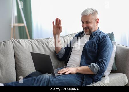 Glücklicher älterer Mann, der von zu Hause aus eine Videokonferenz abhalten kann Stockfoto