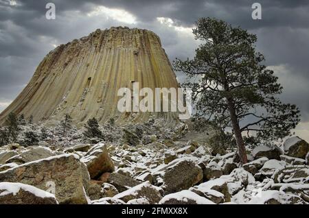 Sturmwolken sammeln sich über dem Devils Tower in Wyoming nach einer Früher Schneefall Stockfoto