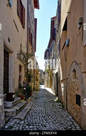 Sermoneta, Italien, 05/10/2021. Eine schmale Straße zwischen den Steingebäuden einer mittelalterlichen Stadt in der Region Latium. Stockfoto