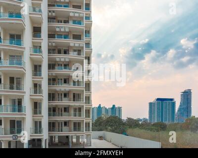 Ein Nahaufnahme eines neu errichteten Gebäudes mit Wolken und blauem Himmel und weiteren Gebäuden im Hintergrund bei Pune India am 9. März 2021 Stockfoto