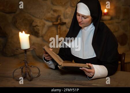 Die junge Nonne studiert die Bibel im Mittelalter Stockfoto