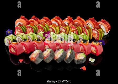 Set aus verschiedenen Sushi-Rollen auf schwarzem Hintergrund Stockfoto