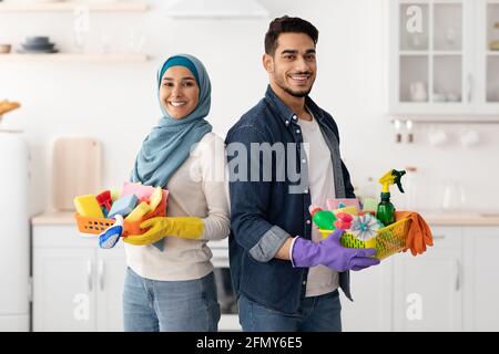 Glückliche muslimische Familie putzt ihre neue Wohnung Stockfoto