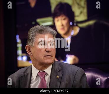 Washington, Usa. Mai 2021. Senator Joe Manchin (D-WV) hört zu, wie Senatorin Susan Collins (R-ME) auf dem Monitor hinter ihm Fragen stellt, während der Ausschuss für die Haushaltsmittel des Senats in Washington, DC, eine Anhörung zur Untersuchung des gewalttätigen häuslichen Extremismus abhält. Foto von Bill O'Leary/Pool/ABACAPRESS.COM Credit: Abaca Press/Alamy Live News Stockfoto