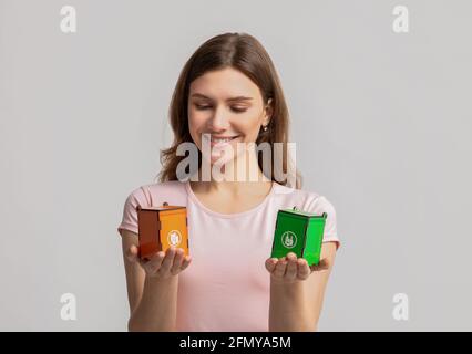 Positive Weibliche Holding Kleine Spielzeug Papierkorb Für Verschiedene Arten Von Materialien Stockfoto