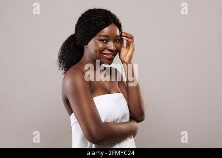 Natürliche Schönheit. Portrait Of Young Smiling Black Female Trägt Badetuch Stockfoto