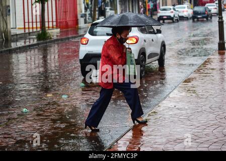 Non Exclusive: TOLUCA, MEXIKO - MAI 12: Eine Frau geht in der Innenstadt mit Sonnenschirmen zu decken, um von den Regenfällen bedeckt zu werden, da die Stadt wi dämmerte Stockfoto