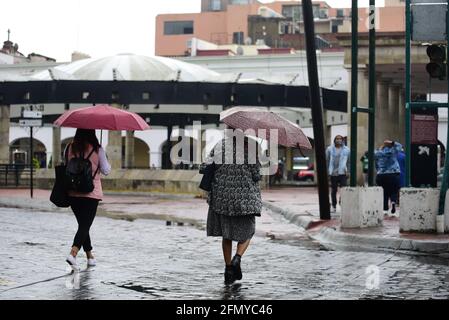 Non Exclusive: TOLUCA, MEXIKO - MAI 12: Zwei Frauen gehen mit Sonnenschirmen in die Innenstadt, um vor den Regenfällen geschützt zu werden, da die Stadt angebrochen ist Stockfoto