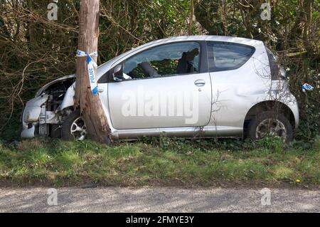 Autounfall. Verlassene Wrackteile eines silbernen Citroën C1 VTR+, der von der Straße abgekommen ist und in einen Telefonmast am Straßenrand stürzte. Dorset, England, Großbritannien. Stockfoto