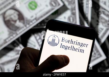 China. April 2021. In dieser Abbildung ist das Logo des forschenden Pharmaunternehmens Boehringer Ingelheim auf einem Smartphone mit US-Dollar-Währung im Hintergrund zu sehen. Kredit: SOPA Images Limited/Alamy Live Nachrichten Stockfoto