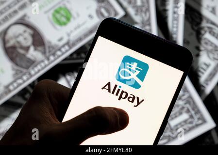 China. April 2021. In dieser Abbildung zeigt die chinesische Online-Zahlungsplattform der Alibaba Group, das Alipay-Logo, das auf einem Smartphone mit US-Dollar-Währung im Hintergrund angezeigt wird. Kredit: SOPA Images Limited/Alamy Live Nachrichten Stockfoto