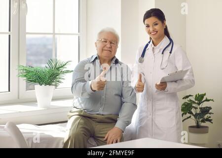 Porträt eines glücklichen zufriedenen älteren Mannes und eines jungen Arztes Daumen hoch zusammen Stockfoto