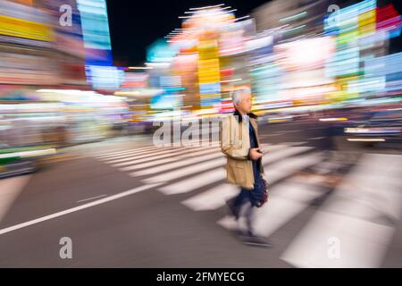 Tokio, Japan - 8. Januar 2016: Bewegungsunschärfe eines japanischen Geschäftsmannes im geschäftigen Viertel Akihabara Electric Town. Stockfoto