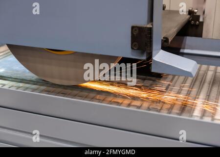 Oberflächenschleifmaschine, die mit Blech mit Funken arbeitet Im Werk Stockfoto