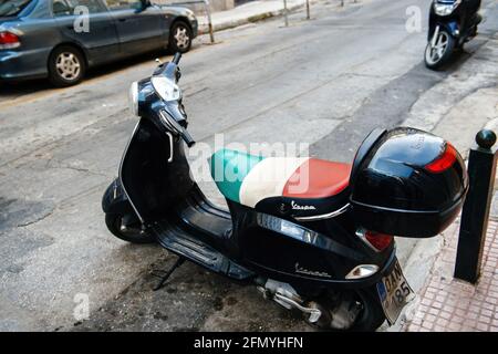 Vespa vintage schwarzes Motorrad auf der schlecht asphaltierten Straße geparkt Stockfoto
