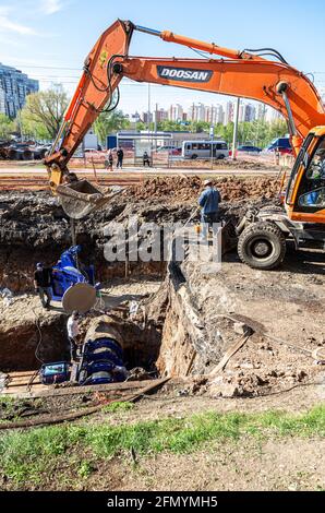 Samara, Russland - 6. Mai 2021: Reparatur und Ersatz der unterirdischen Kommunikation auf der Stadtstraße. Ersatzrohre der Heizleitung im Sommer Stockfoto