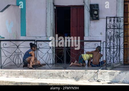 Kubanische Kinder spielen auf einer verwitterten alten Haustreppe. Lifestyle in Santiago de Cuba, Kuba Stockfoto