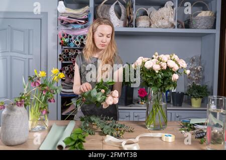 Blumengeschäft Konzept . Floristin Frau schafft Blumenstrauß. Schönes Bouquet von gemischten Blumen. Schöner frischer Haufen. Lieferung von Blumen Stockfoto