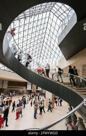 PARIS - Interier des Louvre Museums. Menschen, die auf Treppen unterhalb der Luvre-Pyramide laufen. Stockfoto