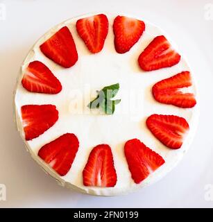 Top-down-Komposition aus hausgemachtem Erdbeer- und Cremeteig mit Minzblättern darauf. Stockfoto